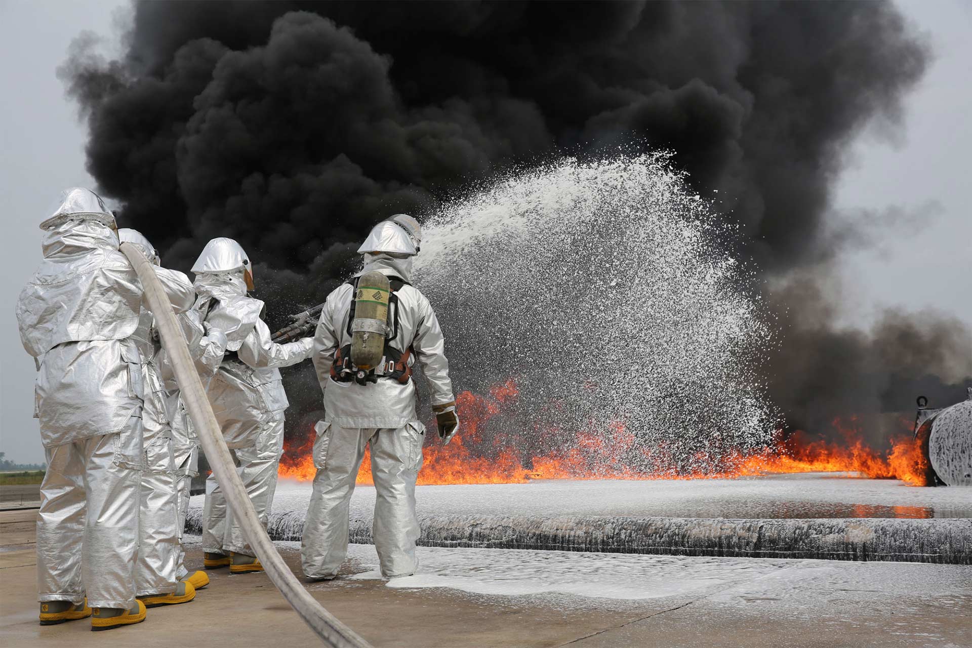 Firefighters using AFFF - Aqueous Film Forming Foam on fire